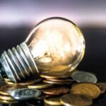 light bulb on over pile of coins