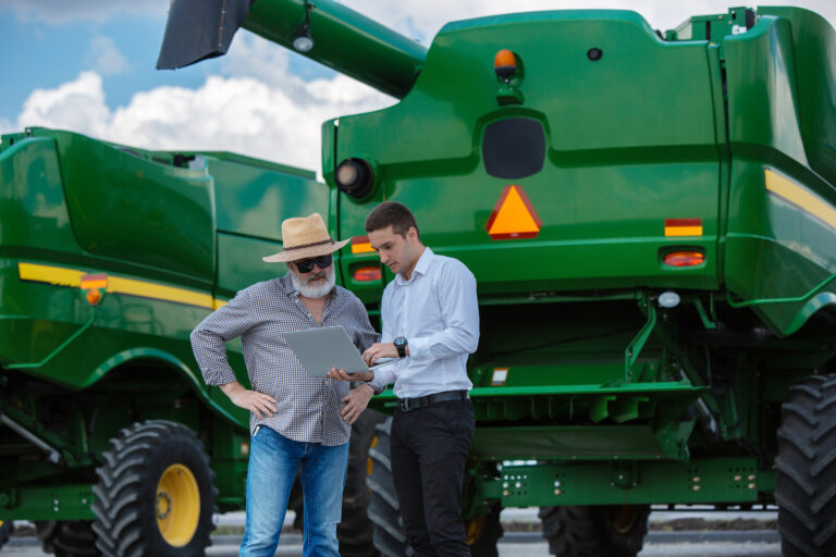 A farmer with a tractor, combine at a field in sunlight. Confident, bright colors