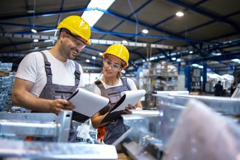 factory-workers-analyzing-production-results-in-large-industrial-hall_342744-164