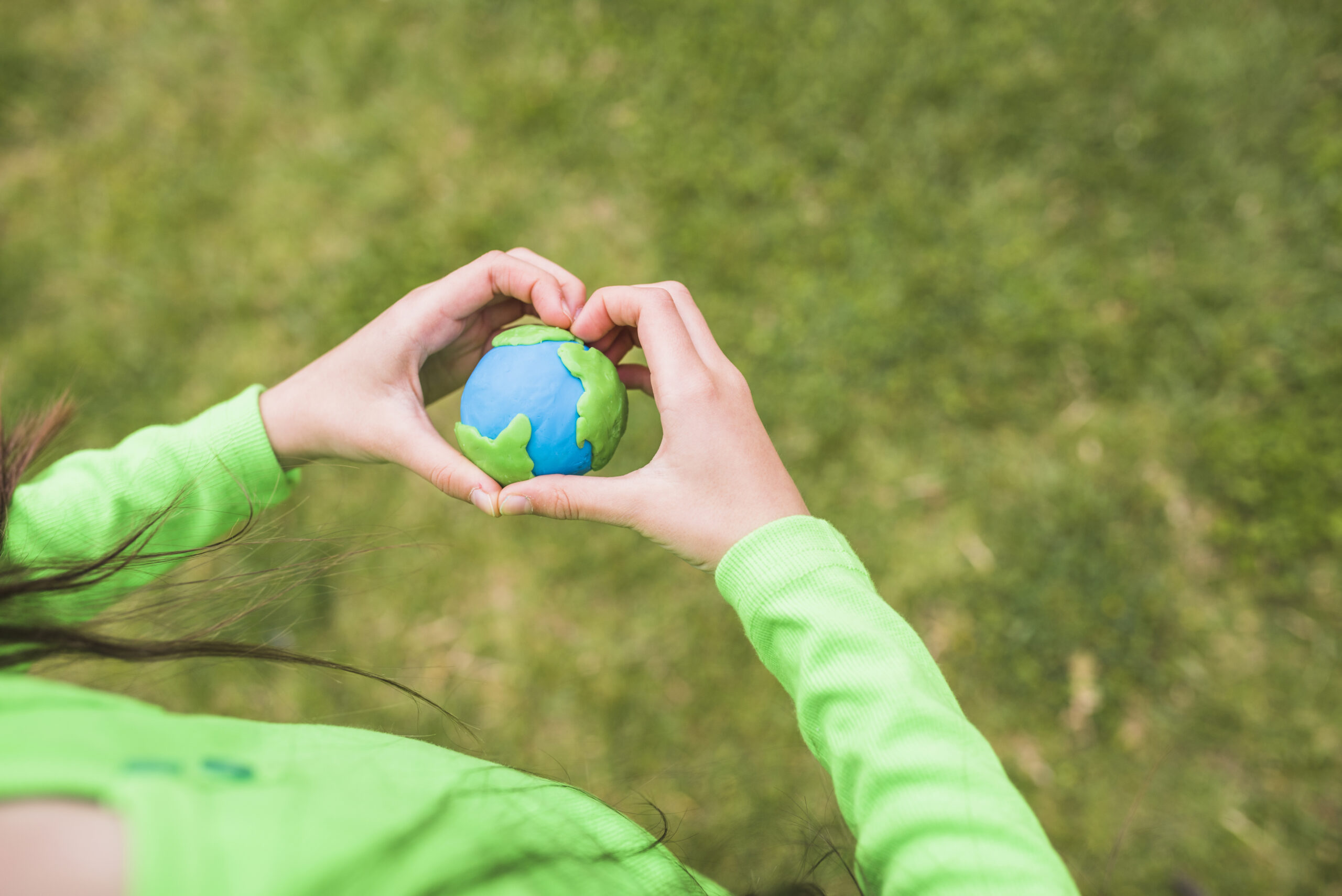 heart-shape-hands-surrounds-the-colorful-plasticine-planet