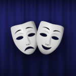 Comedy and Tragedy theatrical mask isolated on a blue curtain background.