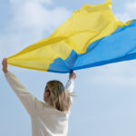 medium-shot-woman-holding-ukranian-flag