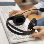 woman-working-in-a-call-center-holding-a-pair-of-headphones