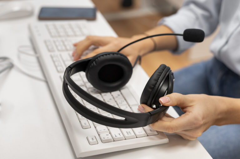 woman-working-in-a-call-center-holding-a-pair-of-headphones