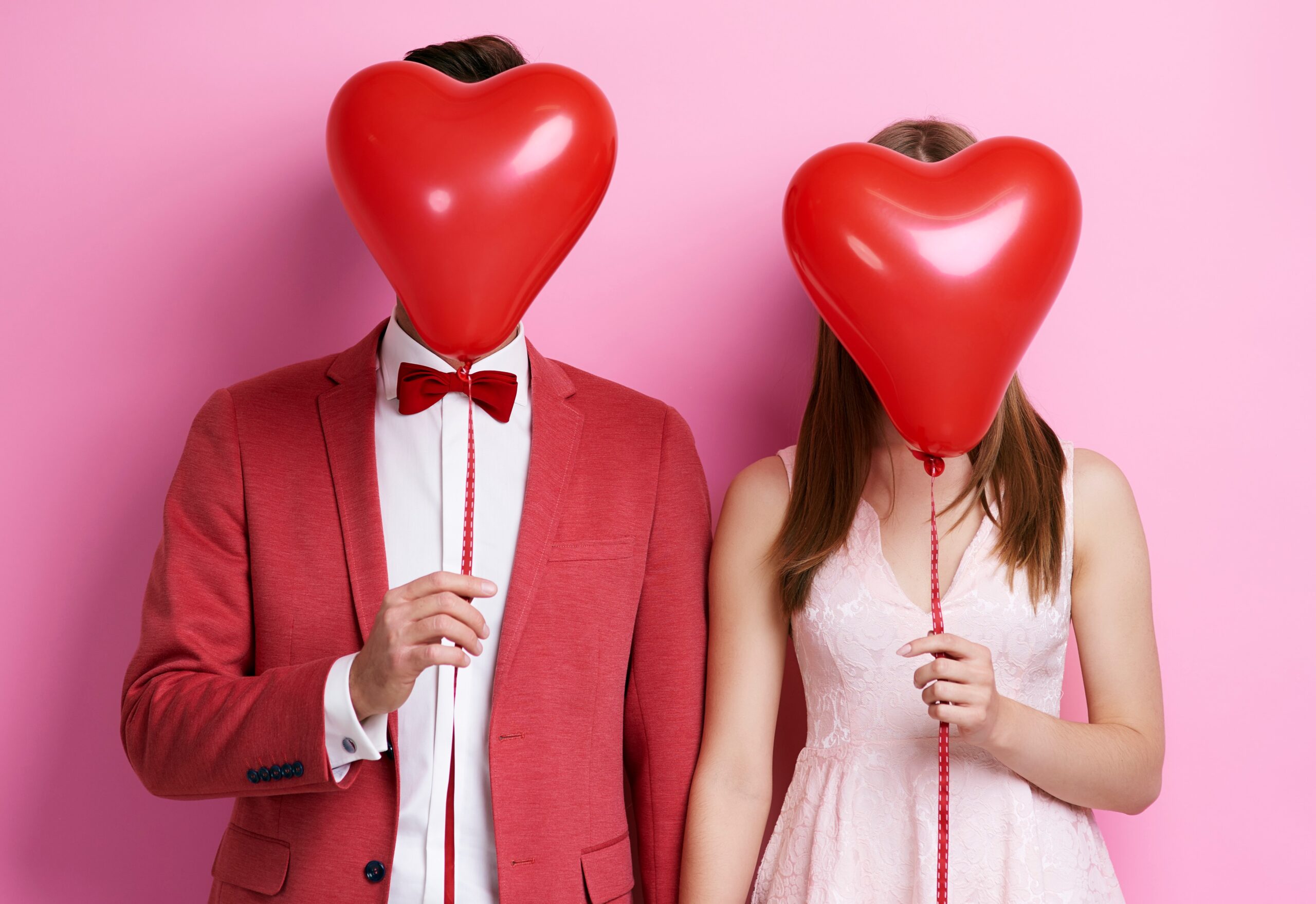 Unrecognizable couple with balloon holding hands