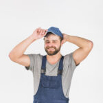 man-in-overall-putting-cap-on-head