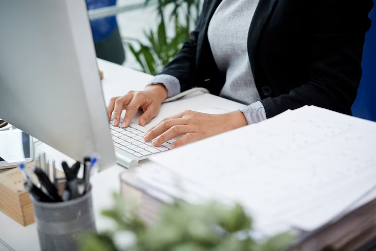 unrecognizable-woman-sitting-at-desk-in-office-and-typing-on-keyboard_1098-20224