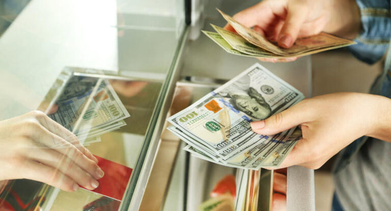 Female hand with money in cash department window. Currency exchange concept