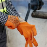worker-putting-on-protective-gloves-1160x560