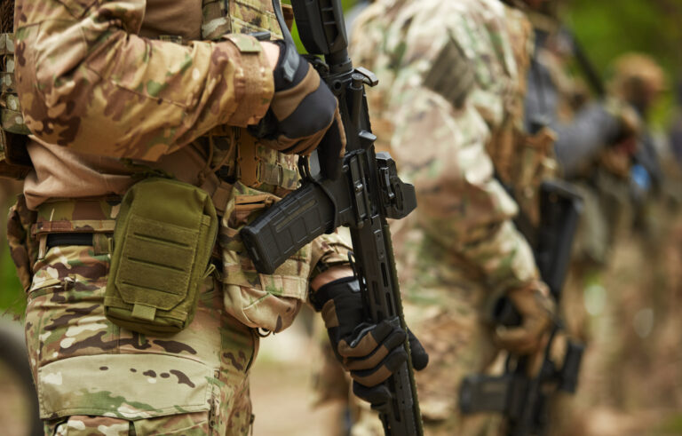 Group of Ukrainian soldiers equipped with modern American assault rifle training at the shooting range outdoor. Armed forces of Ukraine fighting for freedom and protecting the country